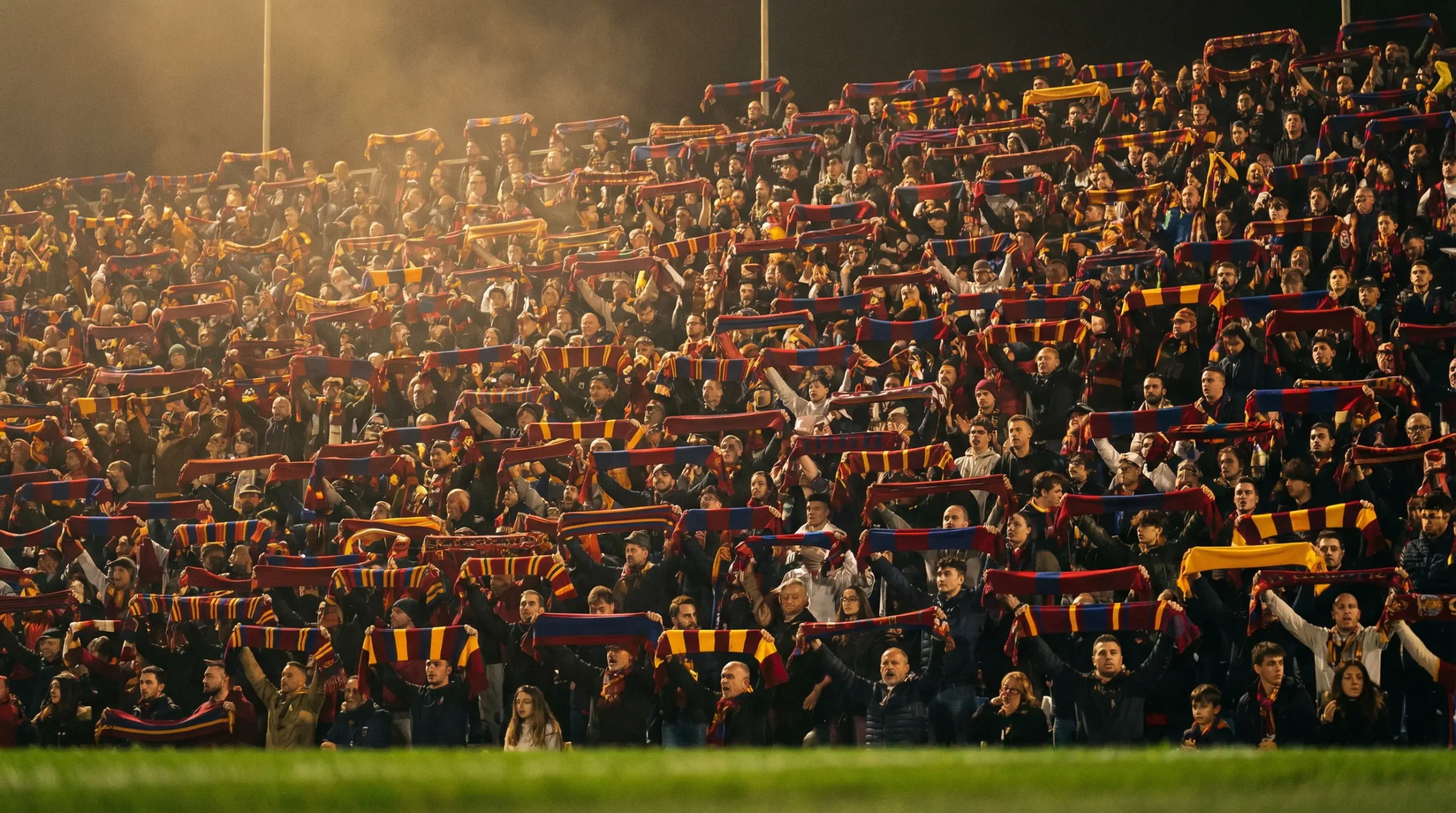 Tribuna gremita di tifosi in uno stadio italiano durante una partita di Serie A in notturna