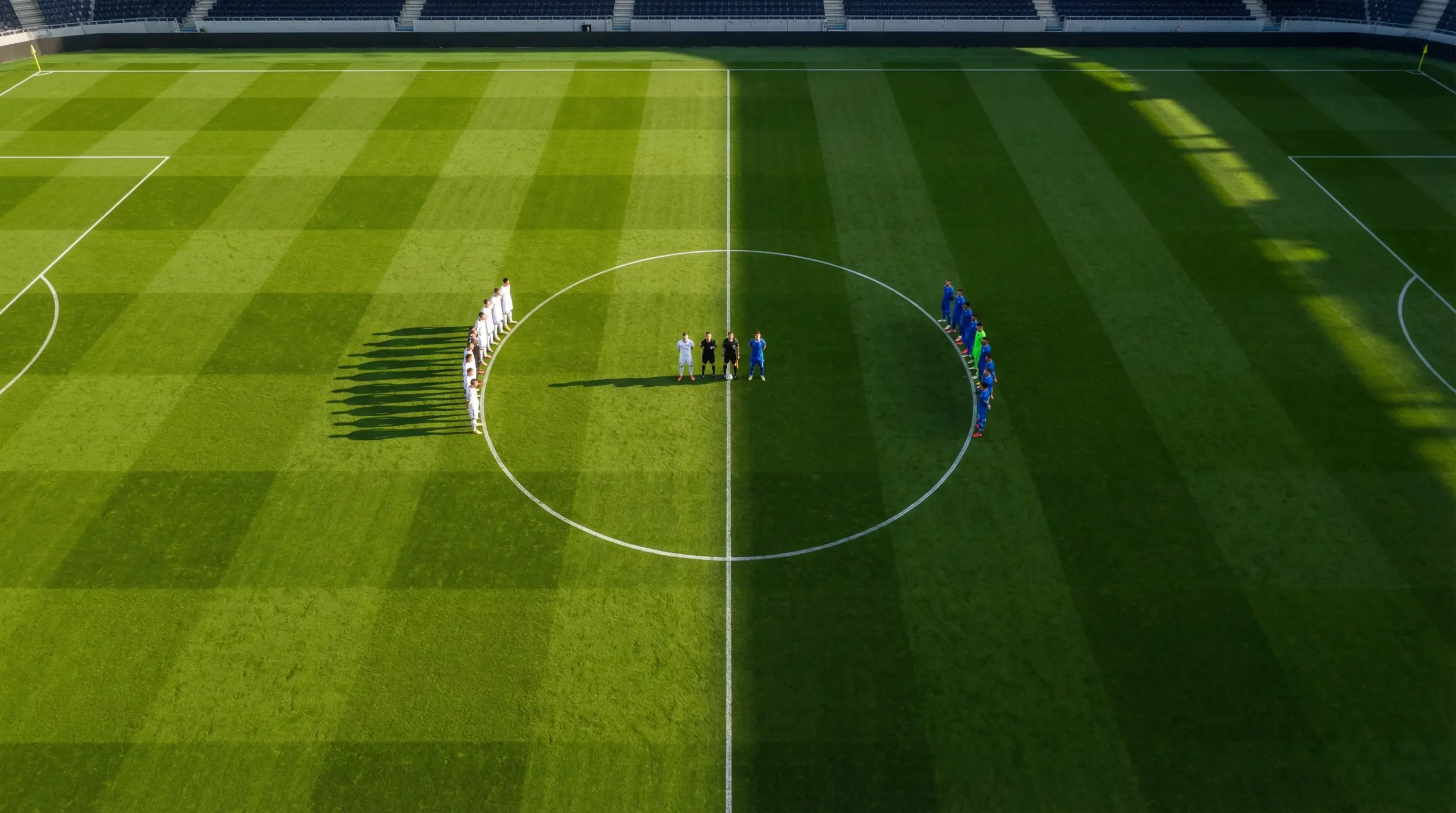 Campo da calcio visto dall'alto con linee di centrocampo e due squadre schierate, concetto di handicap nelle scommesse